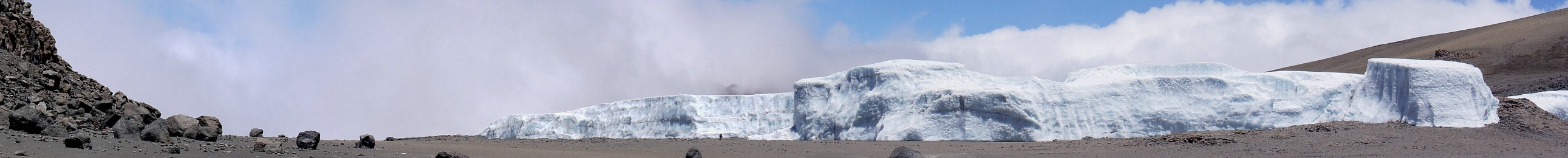Der Furtwängler Gletscher in der Kibo-Kaldera im Jahr 2008. Zum Größenvergleich betrachtet man die beiden Bergsteiger auf dem Weg in die Schneise zwischen den Gletscher-Segmenten